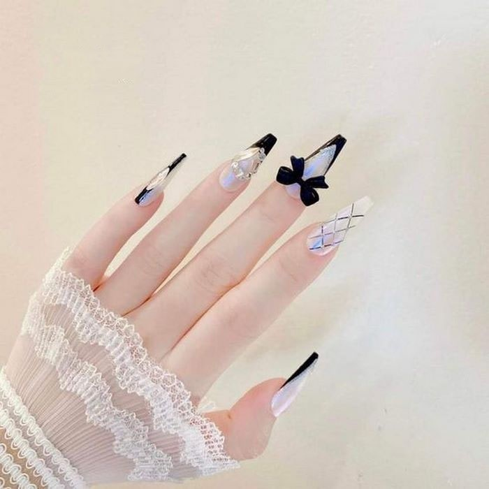 Luxurious black and white nails with long pointed nail shape