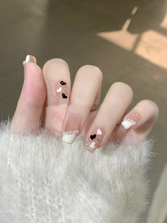 Break out the style with pink rhinestone nails studded with black stones