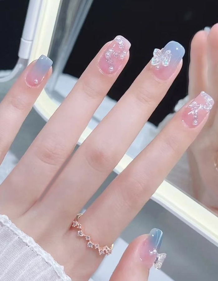 Blue and pink jelly nails are harmoniously decorated with a striking bow