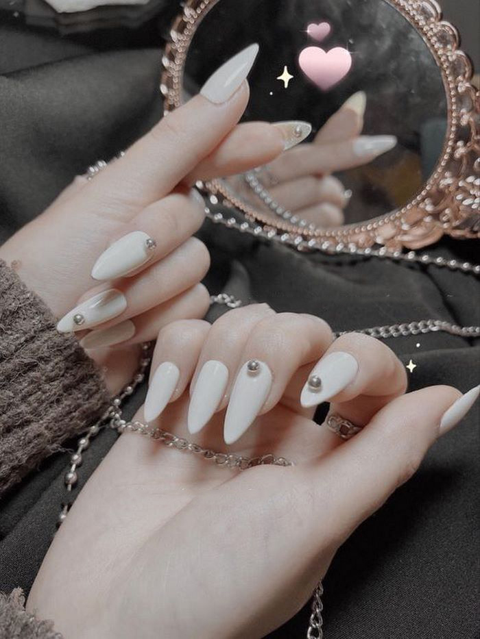 Elegant white nail design with pointed round stones, suitable for many hand shapes