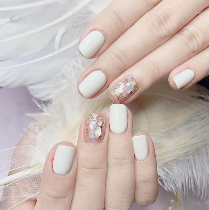 White nail design combined with striking stones