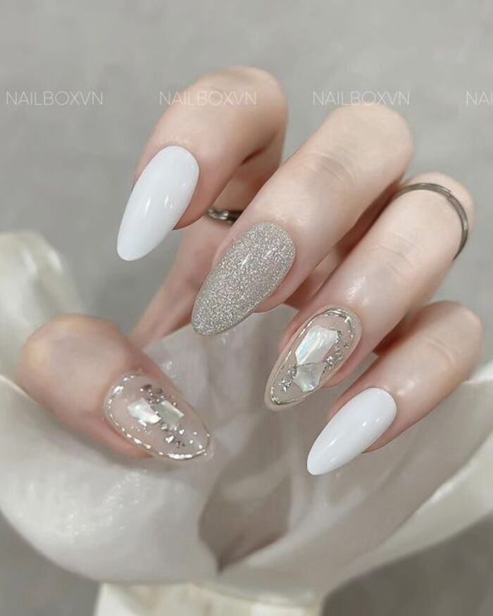 White nail design with white nails mixed with glitter and sparkling stones