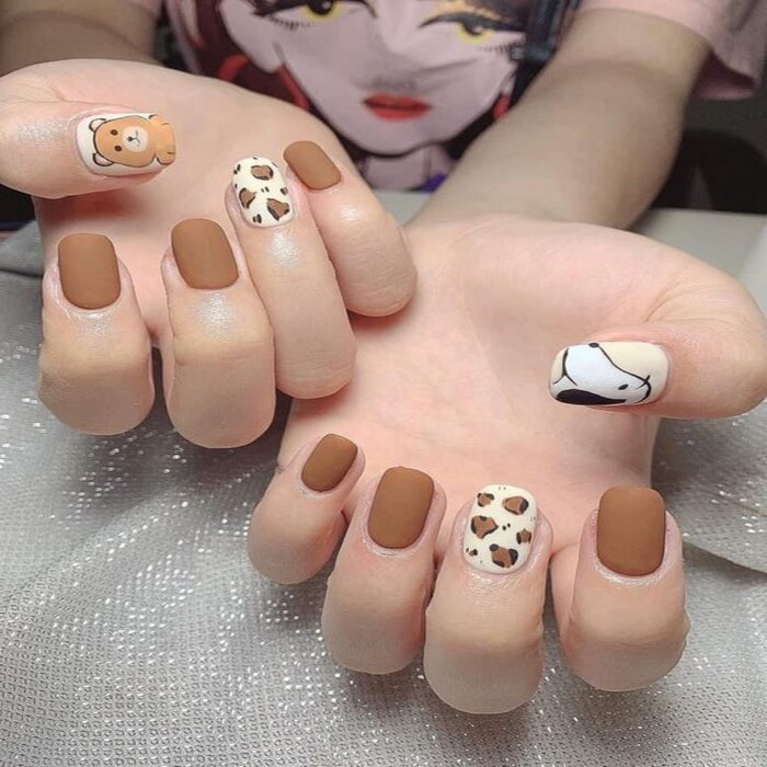 Round nails combine white and brown with eye-catching patterns