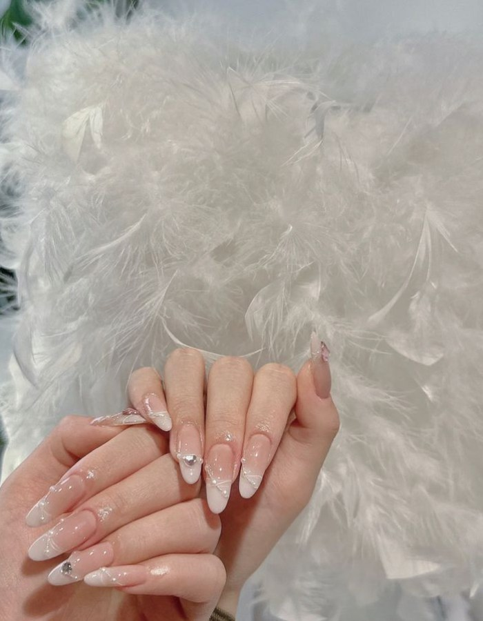Paint rhinestones on long nails with rhinestones and simple lines
