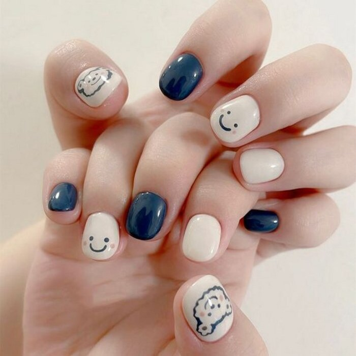 Blue and white nail art combined with a smiley face