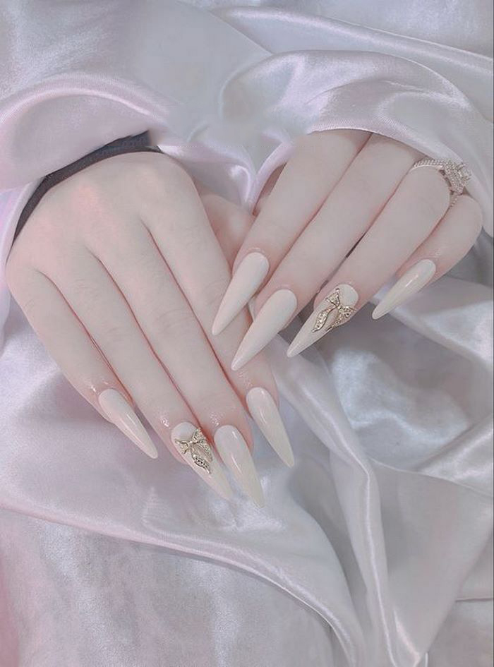 Add white pointed nail designs with stones or patterns