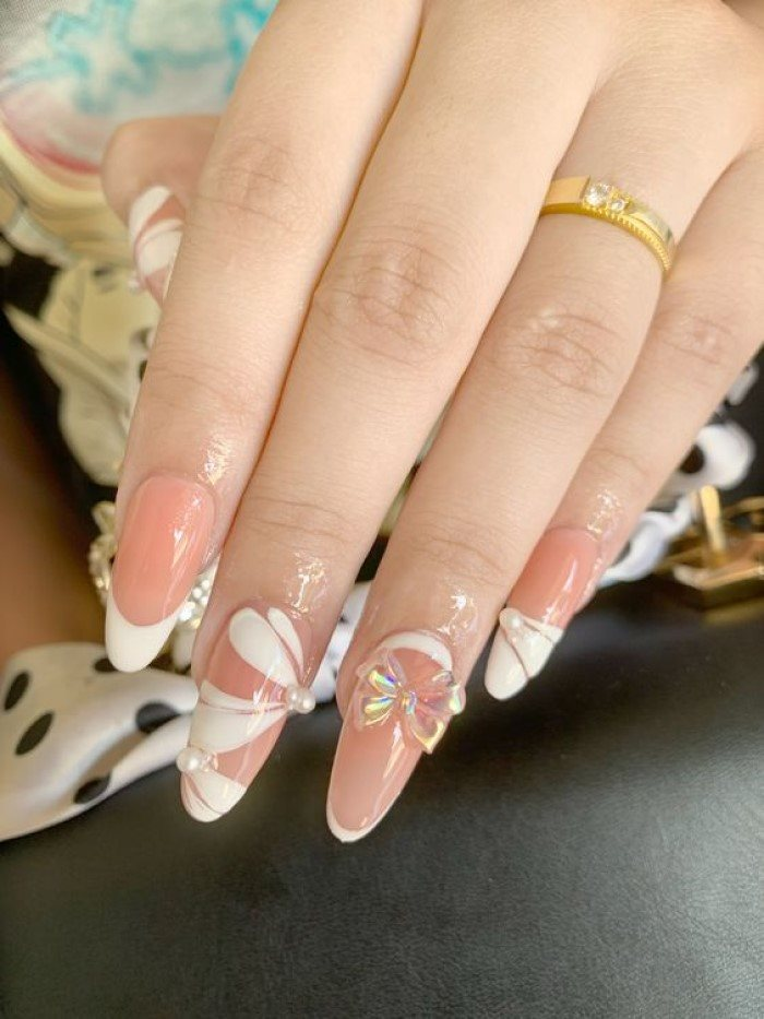 Pink pointed round nail design with beautiful white motifs