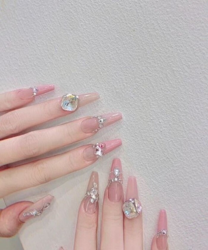 Long natural pink nail design with large stones