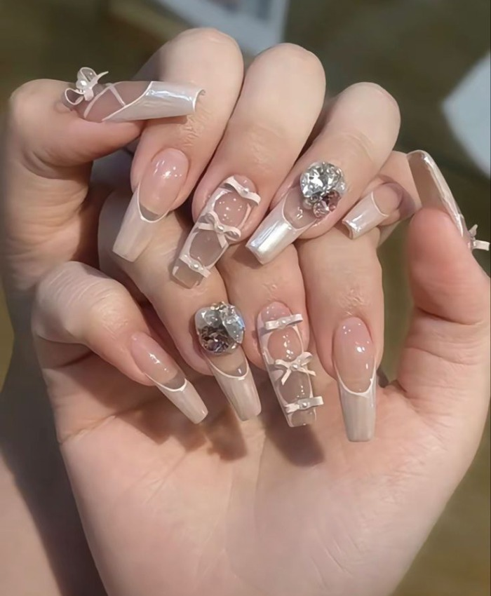 Màu móng tay độc đáo cho da ngăm trong suốt điểm nâu đính nơ và đá giúp tôn lên làn da trắng hồng