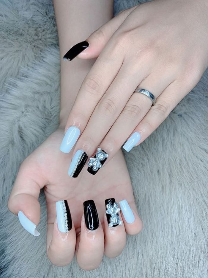White nails combined with black with stones and interesting bear charms