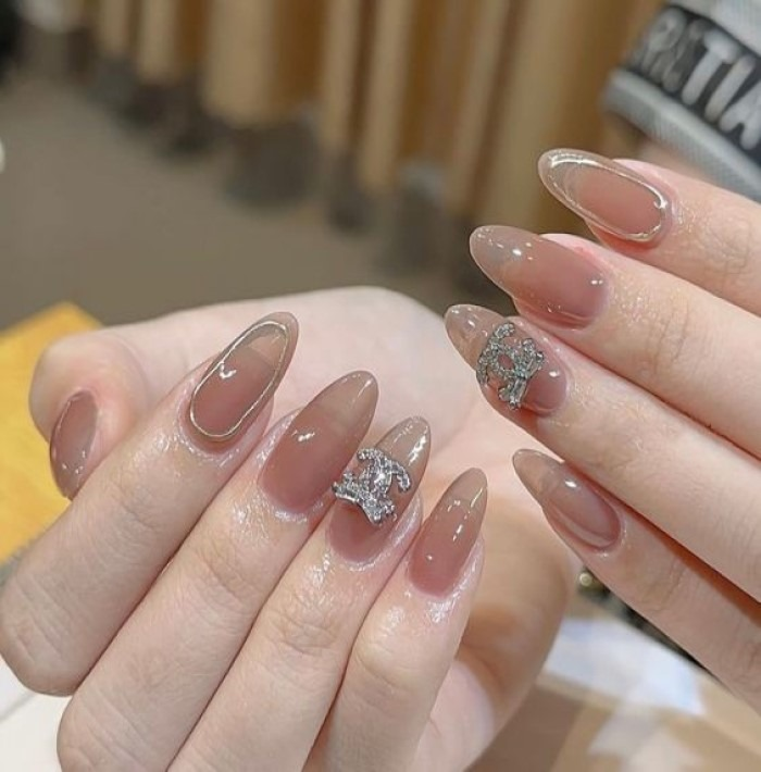 Simple pink pointed nail design with a few stones