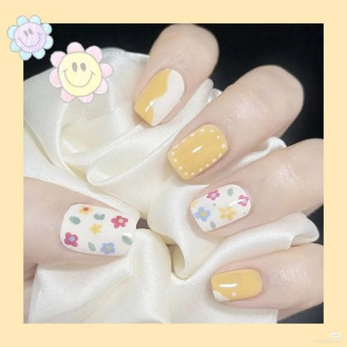 Short yellow and white nails painted with flowers