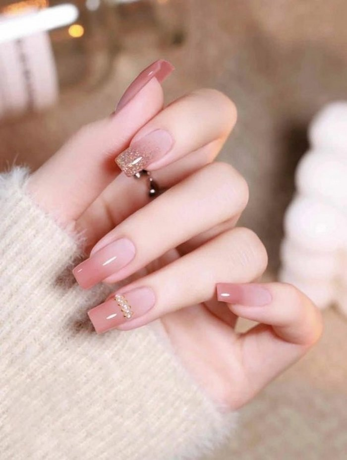 Pink nails with charms are painted ombre