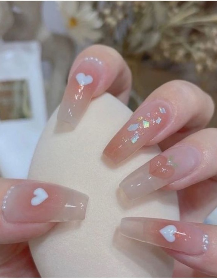 Beautiful rhinestone nail design depicting a heart with feminine pearls