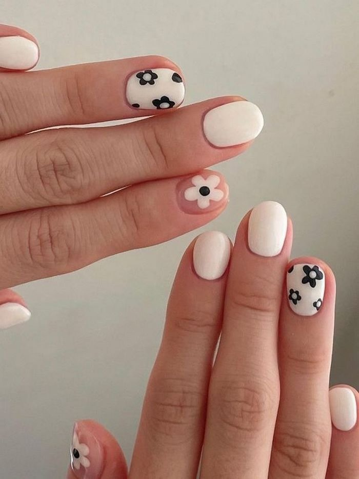 Round nails with white background and unique black patterns