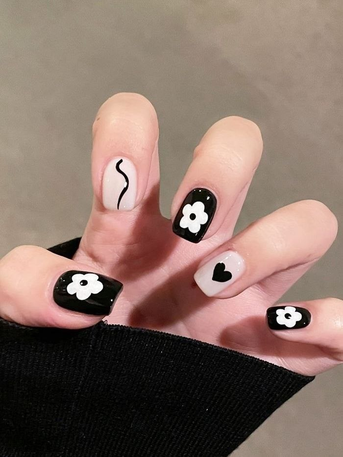 White and black nail designs with floral and heart motifs