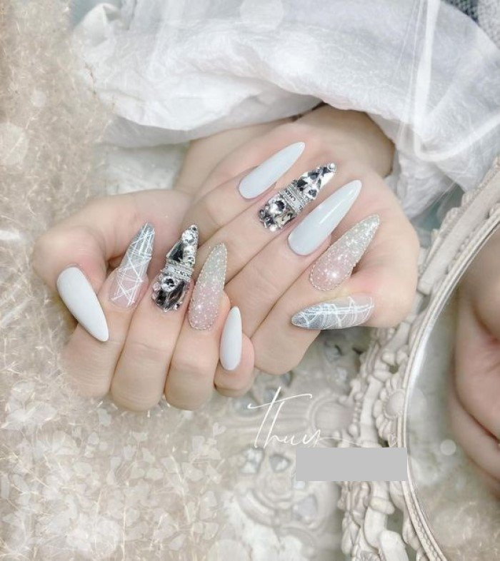 White pointed round nail form combined with beautiful stones