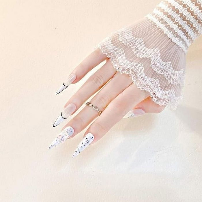 Nail design painted white, with black nail tips combined with polka dots