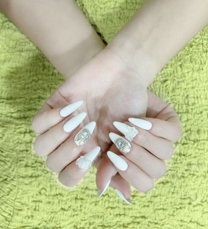 White nail design for long, pointed brides with striking stones