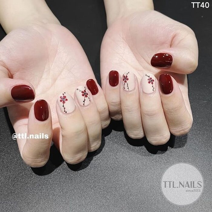 Nail đỏ với họa tiết bông hoa làm điểm nhấn thường được lựa chọn vào dịp Tết