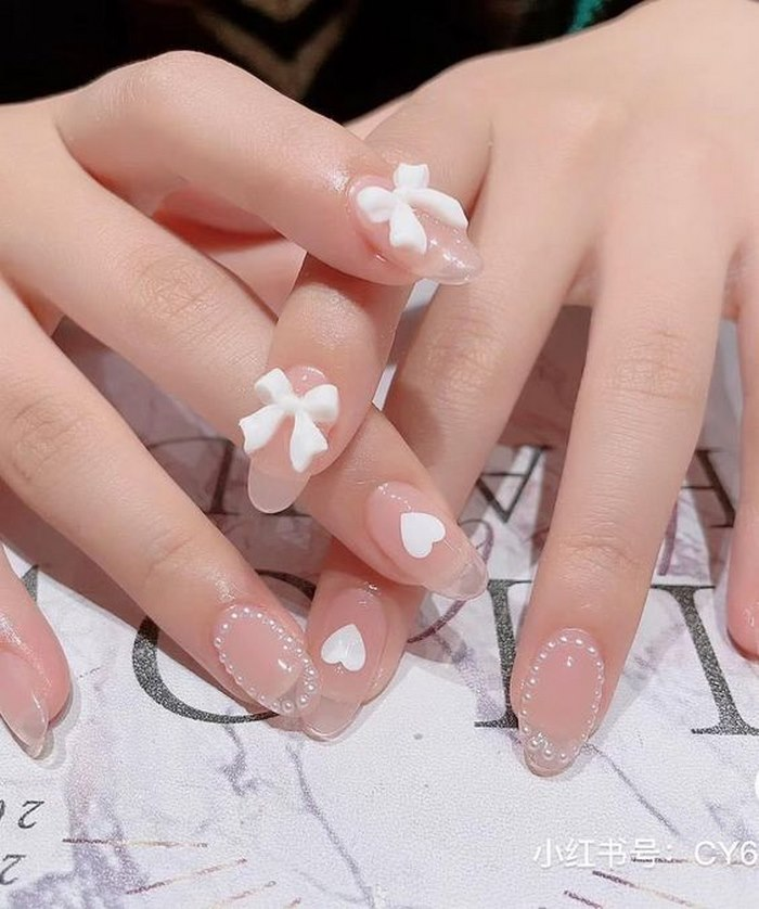 Pink nails with rhinestones and bow motifs are super beautiful